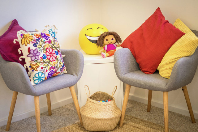 The therapy room's reading corner, with soft chairs and cushions
